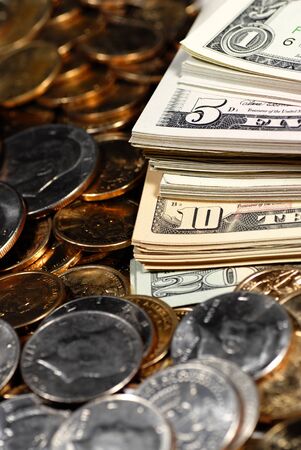 Coins and dollar bills representing wealth and savingsの写真素材