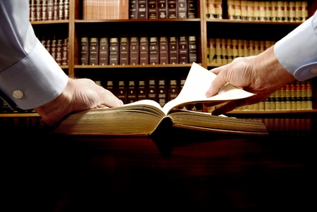 Hands holding an old book with library in background