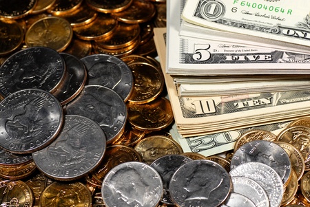 Coins and dollar bills representing wealth and savingsの写真素材
