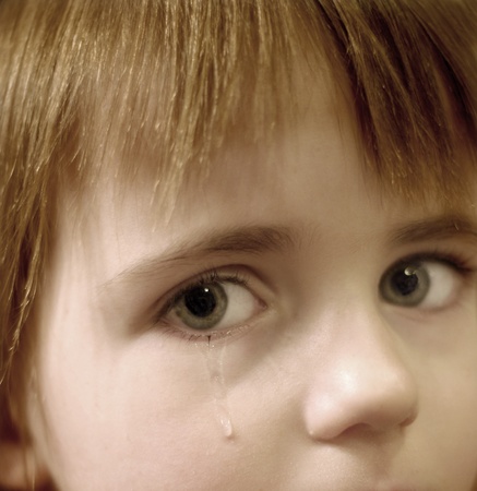 Portrait of little girl crying with tears rolling down her cheeks