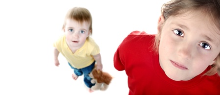 Portrait of little sisters with red & yellow shirts on white backgroundの写真素材