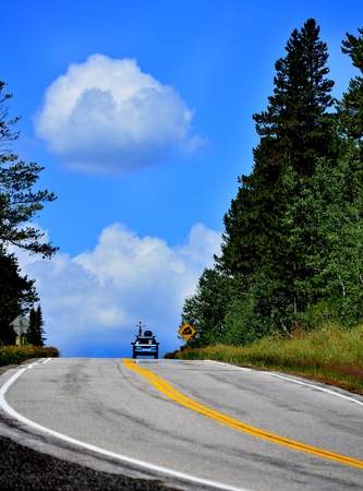 Car with bike on top driving on mountain roadの写真素材