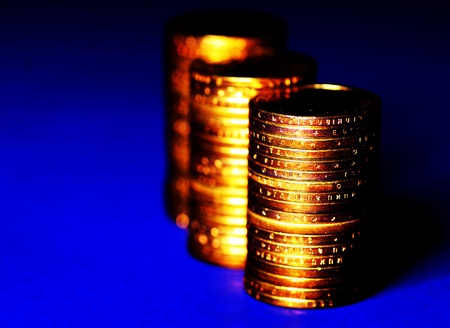 Several stacks of gold coins on blue backgroundの写真素材