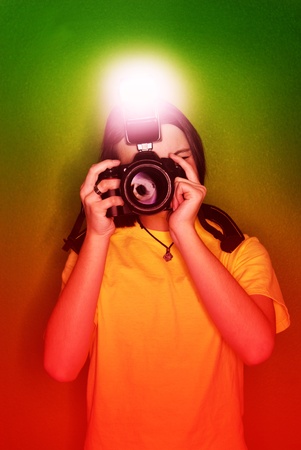 Girl photographer taking photo with digital camera and flashの写真素材