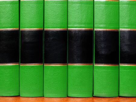Row of old gree leather books on a shelf with blank coversの写真素材