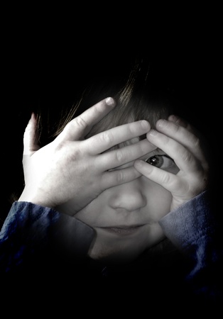 Little girl playing peek a boo with her handsの写真素材