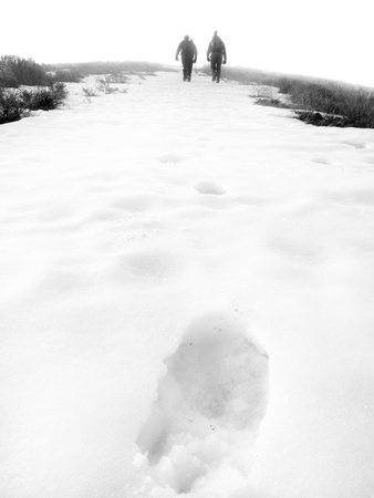 Several people climbing along rocky ridge on a trail in the fogの写真素材