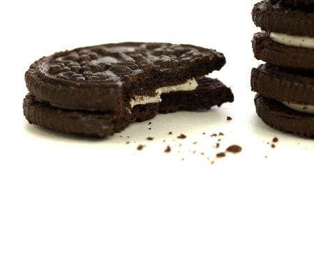 Chocolate cookies with creme filling and crumbs on white backgroundの写真素材