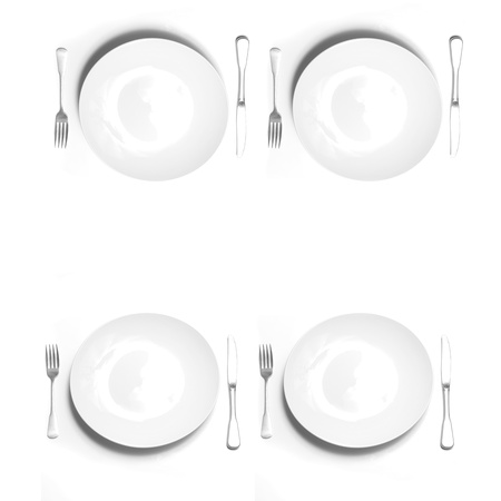 Knives and forks silverware with white plates on white backgroundの写真素材