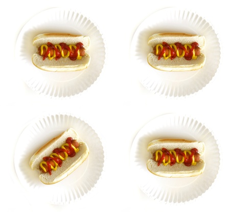 Hot dog on a bun on a white plate with ketchup and mustardの写真素材