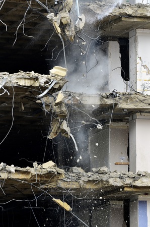 Building collapsing or being demolished with debris falling down
