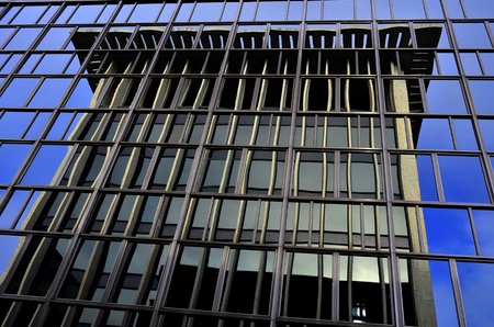 Business building reflected in glass windows of another building in a big city