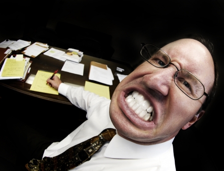 Mean looking man in business office gritting teethの写真素材