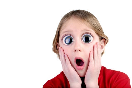Young girl with surprised look holding hands on faceの写真素材