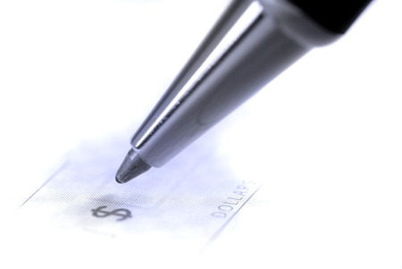 Person writing check with pen and checkbookの写真素材