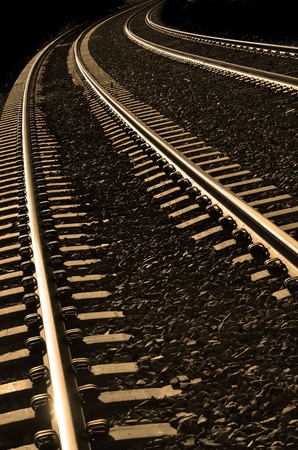 Long bright, railroad tracks curving around bendの素材 [FY31021532939]