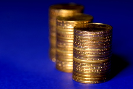 Several stacks of gold coins on blue backgroundの写真素材
