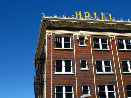 Old hotel with yellow sign and blue skyの写真素材
