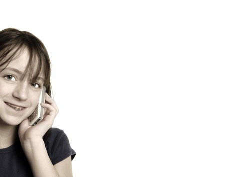 Young happy girl talking on cellphone with white backgroundの写真素材