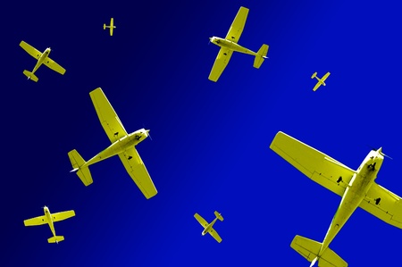 Several yellow airplanes flying across deep blue sky in different directions symbolizing confusion and dangerの写真素材