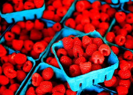 Plump berries in bins on display for sale at the marketの写真素材