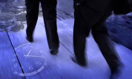 Group of businessmen walking and holding briefcases with money and a clock surrounding them symbolizing speedy businessの写真素材