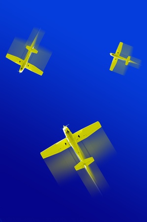 Several yellow airplanes flying fast across deep blue skyの写真素材