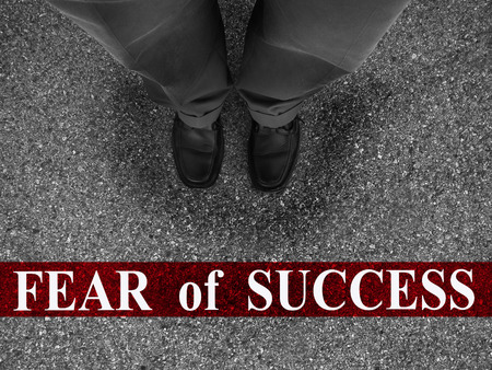 Businessman standing on asphalt starting line with word fear of successの写真素材