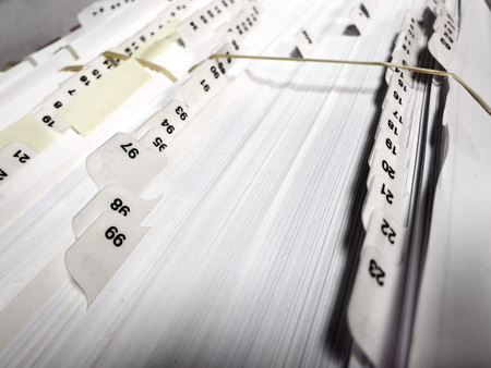 Several numbered business file tabs on papers and pages in a folderの写真素材