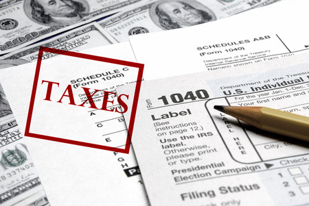 Detail closeup of current tax forms and pencil on money の写真素材