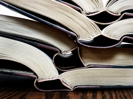 Stack of old books on a desk or table in a libraryの写真素材