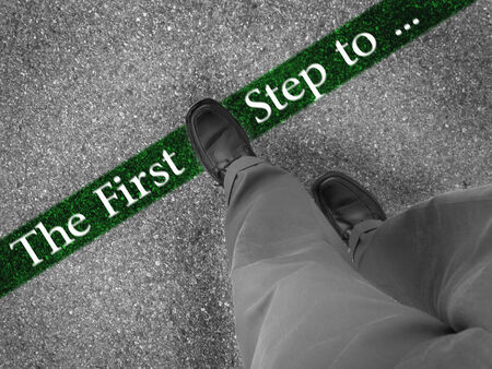 Man walking across a green line with words the first step toの写真素材