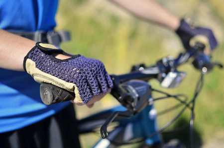 Detail of mountain biking wearing blue exercise shirt and glovesの写真素材