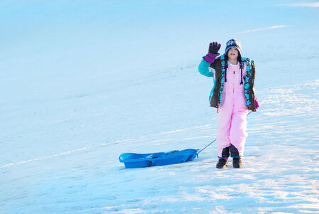 Little girl sledding in winter snow
