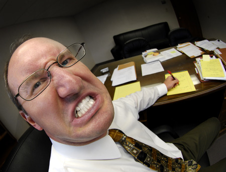 Mean looking man in business office gritting teethの写真素材