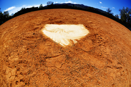 Baseball home plate with dirt and sky curved like a worldの写真素材