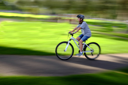 Young Woman Riding Mountain Bike in City Parkの写真素材