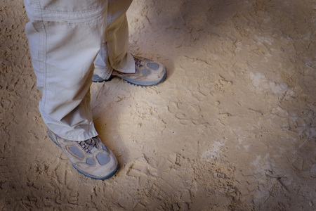 Hiker wearing hiking boots muddy sitting on rockの写真素材