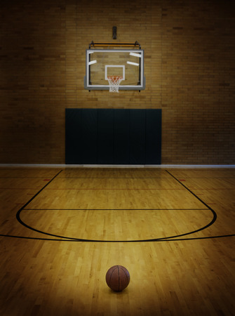 Basketball on floor of empty basketball courtの写真素材