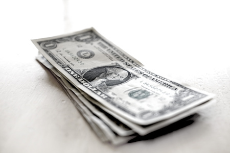 Closeup of several dollar bills isolated on white backgroundの写真素材