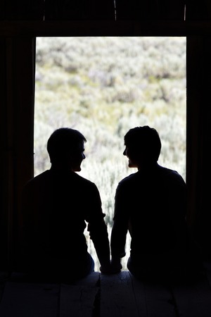 Silhouette of Boyfriend and Girlfriend in love in old barn windowの写真素材