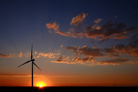 Windmill with sunset and clouds generating electricity and sustainable powerの写真素材