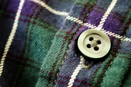 Closeup of button on plaid flannel shirt