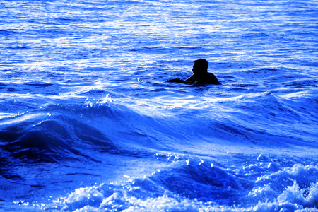 Swimming in ocean surf and waves for recreationの写真素材