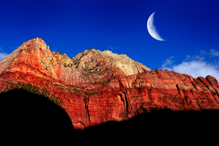Red rock cliffs in Zions National Park Utah explore wilderness rugged mountains with crescent moonの写真素材