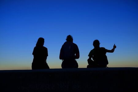 Family at sunrise or sunset together with thumbs up