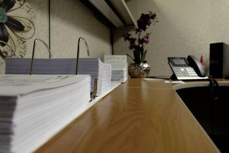 Office workspace desk area with binder phone and decorations