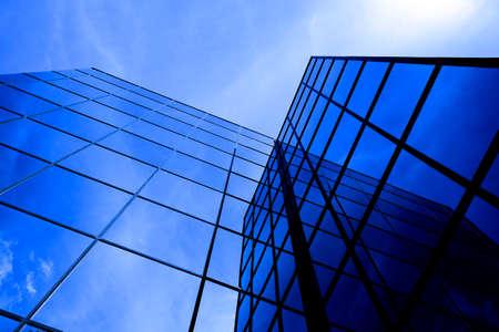 Business building with mirrored windows highrise financial with sky and cloudsの写真素材