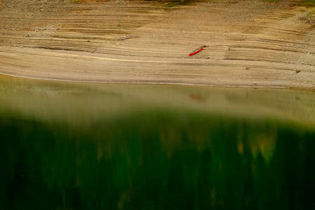 Lakeside forest forrest with pine trees reflection in mountain lake canoe autumn fallの写真素材