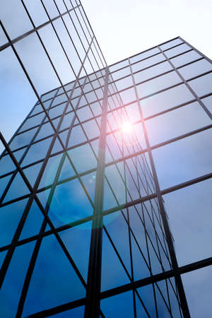 Tall modern building skyskraper windows reflecting sunlightの写真素材